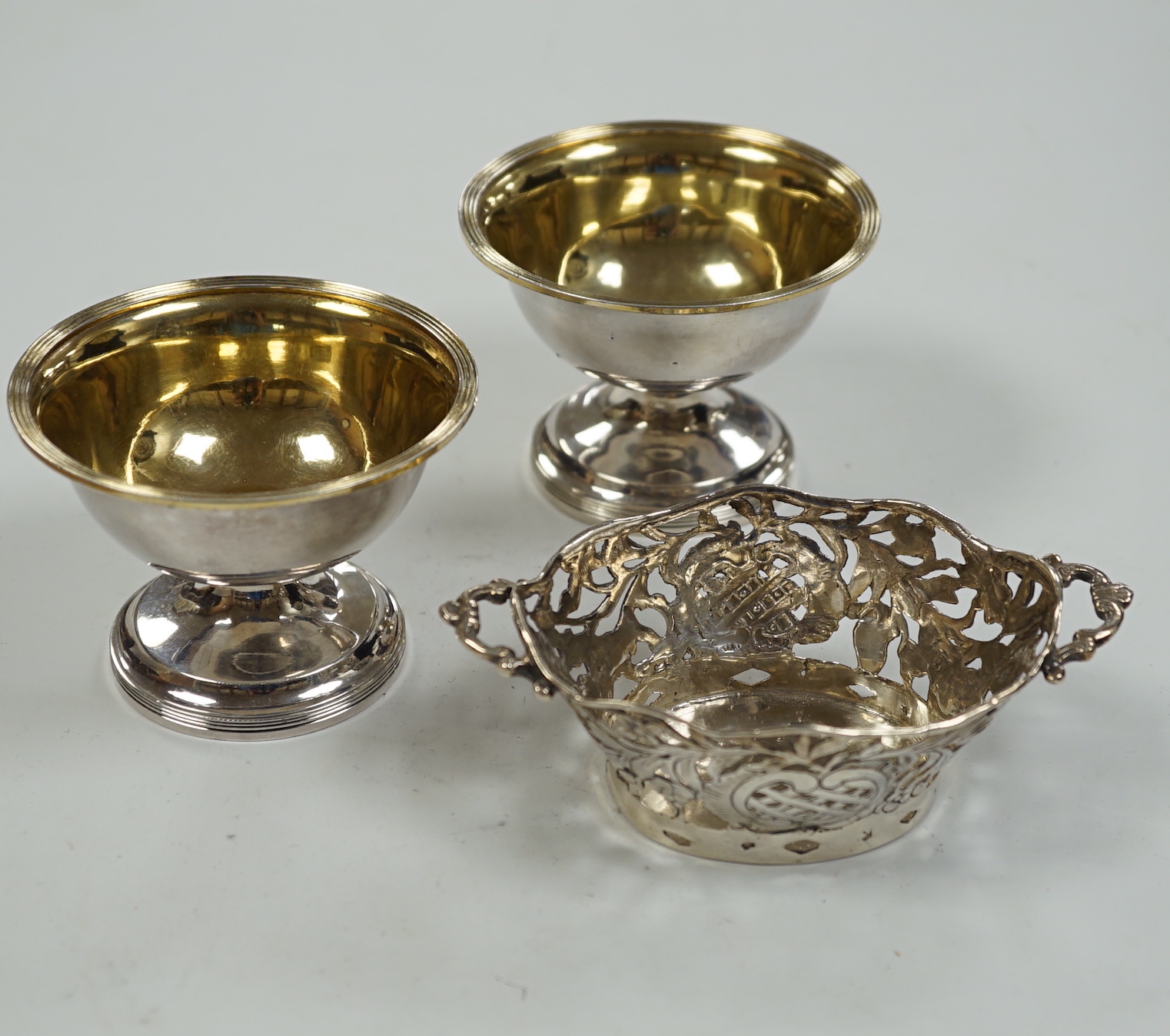 A pair of George III silver circular pedestal salts, John Kidder?, London, 1799, diameter 78mm and a small Hanau silver two handled dish.